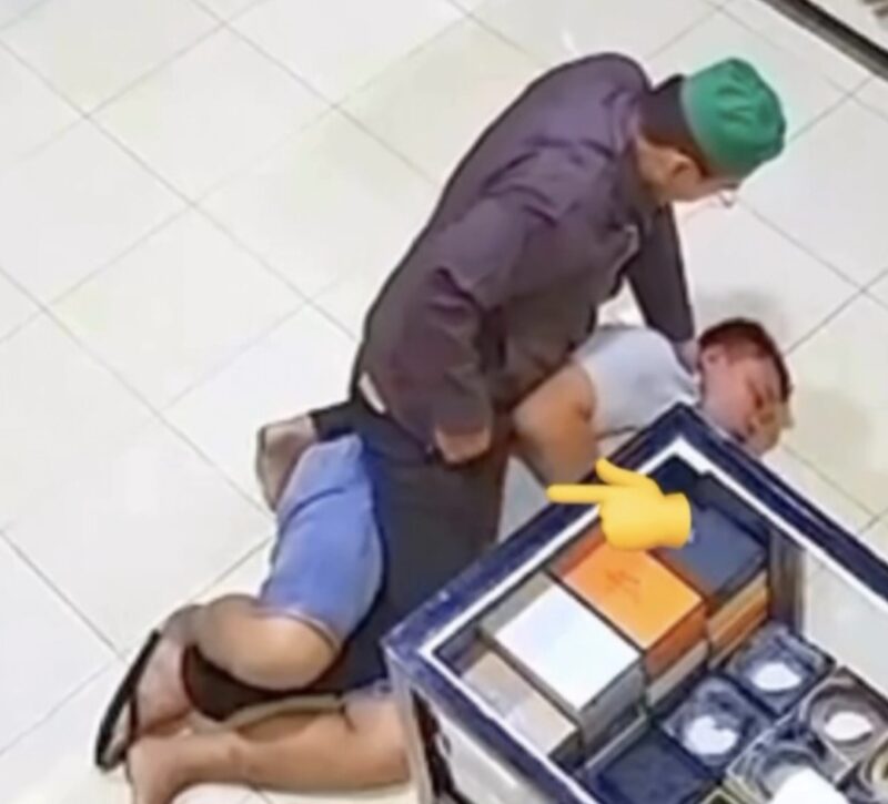 Oknum polisi terlihat berusaha mengeluarkan sesuatu diduga sabu dari saku celananya sendiri (moji tunjuk-red) saat membekuk dan menghimpit Rahmadi.(Ist)